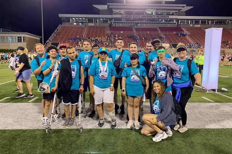 Group photo of Special Olympics athletes and supporters on a football field.