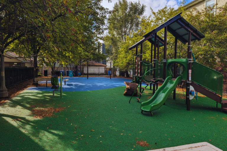 Photograph of playground equipment with green and blue rubber surfaces.