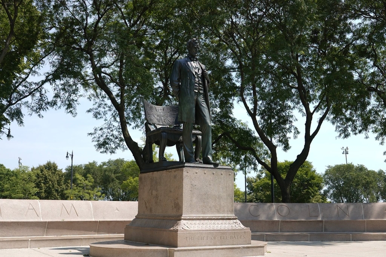 Bronze statue of Abraham Lincoln standing before a bench in Lincoln Park, Chicago.