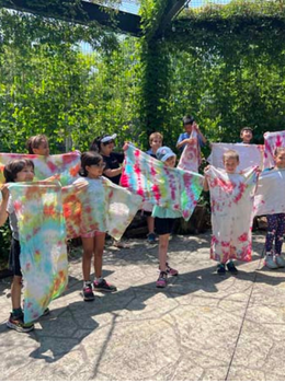 Children proudly display their colorful tie-dye creations.
