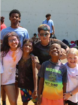 Smiling children covered in colorful powder.