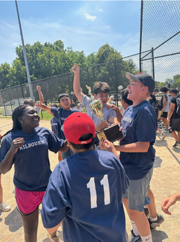 Baseball team celebrates with a trophy after winning a game.