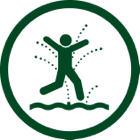 Person joyfully jumping in splash pad.
