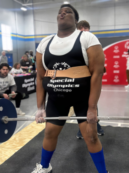 Powerlifter exhales while lifting barbell at Special Olympics Chicago.