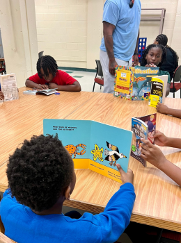 Children reading books at a table.