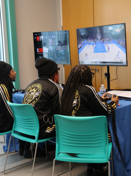 Two students play a basketball video game.