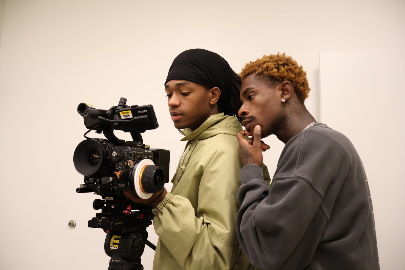 Two people review footage on a Sony professional video camera.