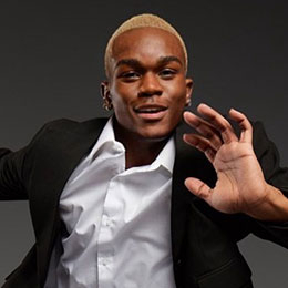 Smiling young man in suit tap dancing.