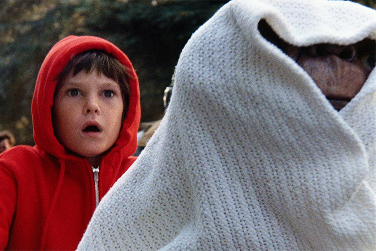 Photograph of E.T. wrapped in a blanket with Elliot.