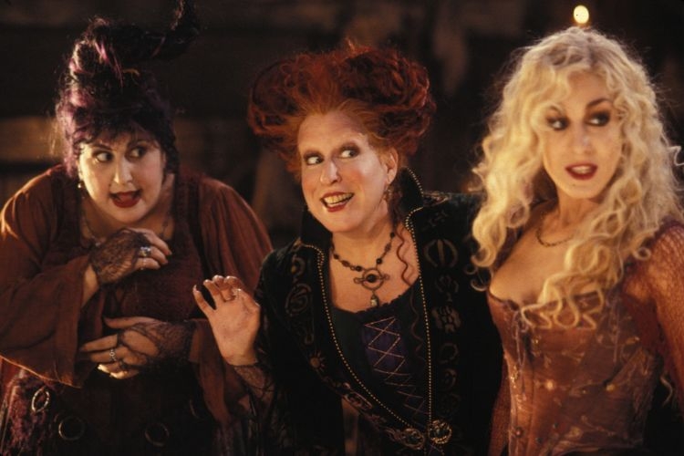 The Sanderson sisters smiling, in costume, photograph.