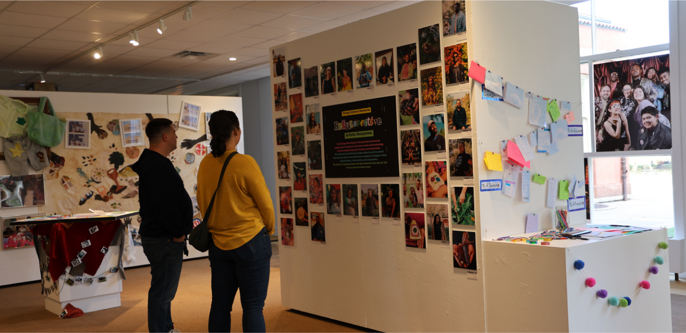 Two people at an art gallery viewing art.
