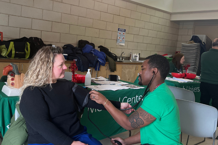 At a health fair, a woman has her blood pressure checked.