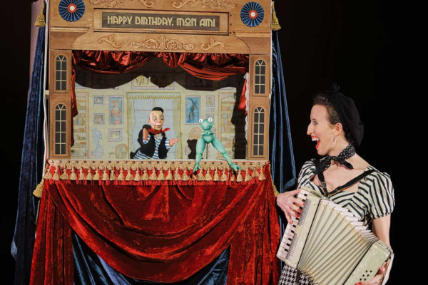 Woman with accordion performs puppet show, "Happy Birthday, Mom Ami".
