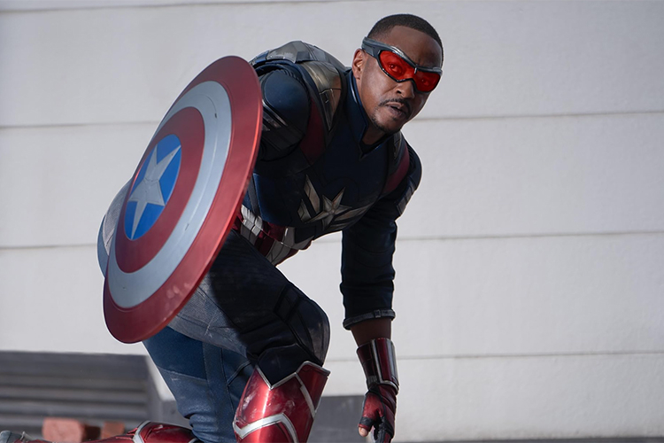 Captain America in a blue suit with a red, white, and blue shield kneeling.