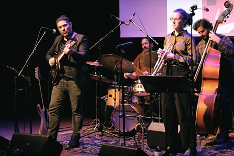 A jazz quartet performs on stage with guitar, drums, trumpet, and upright bass.