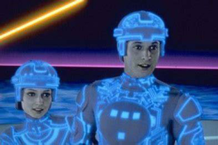 Two figures in Tron-style suits with glowing blue circuitry patterns in a digital environment.