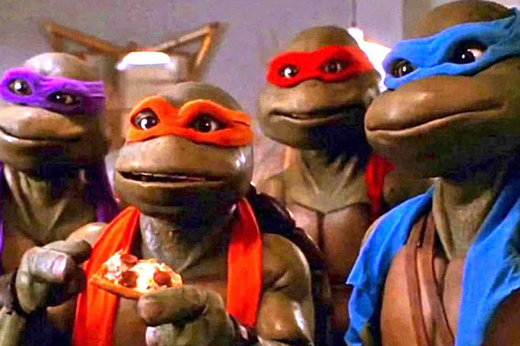 The four Teenage Mutant Ninja Turtles, wearing their signature colored masks, eating pizza.
