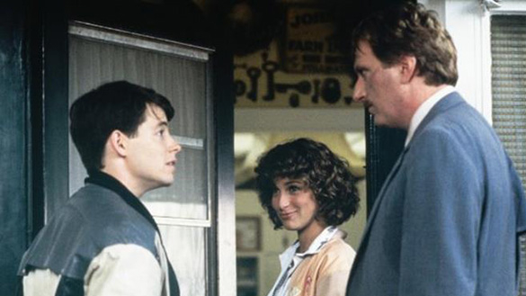 Photograph of Ferris Bueller talking to an adult, while a woman smiles in the background.