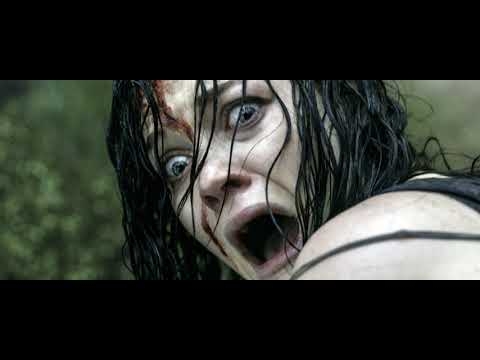 Close-up of a terrified woman with wet, messy hair and blood on her forehead and face.