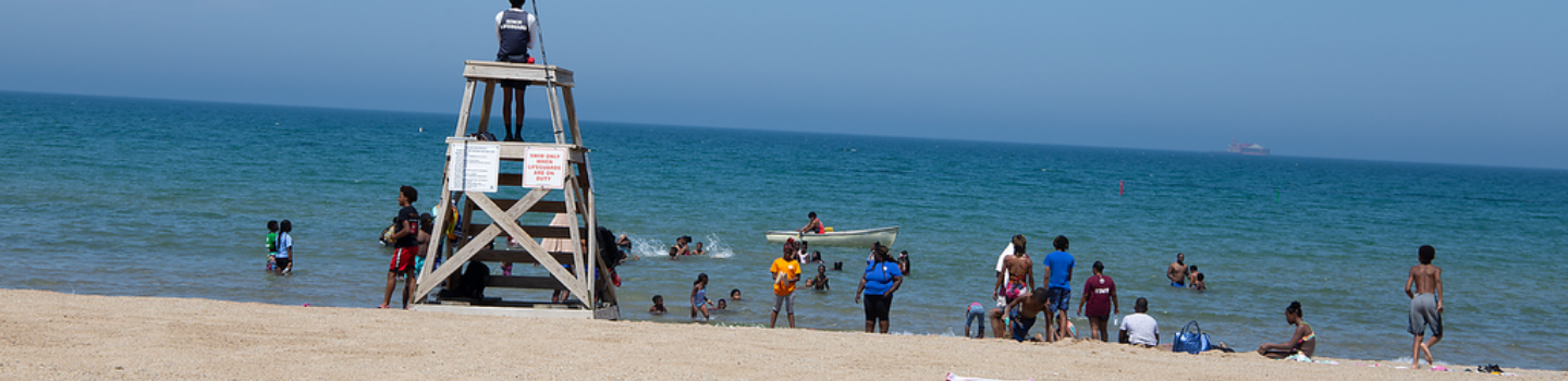 Beaches.png Lifeguard watches swimmers from a chair on a sandy beach.