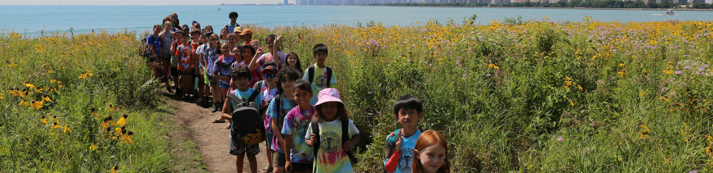Natural Areas.png Children hike on a trail through wildflowers with a city skyline across the water.