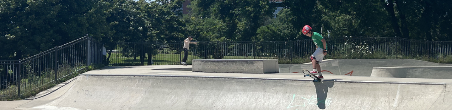Skate Parks.png Child skateboarder atop ramp at skatepark.
