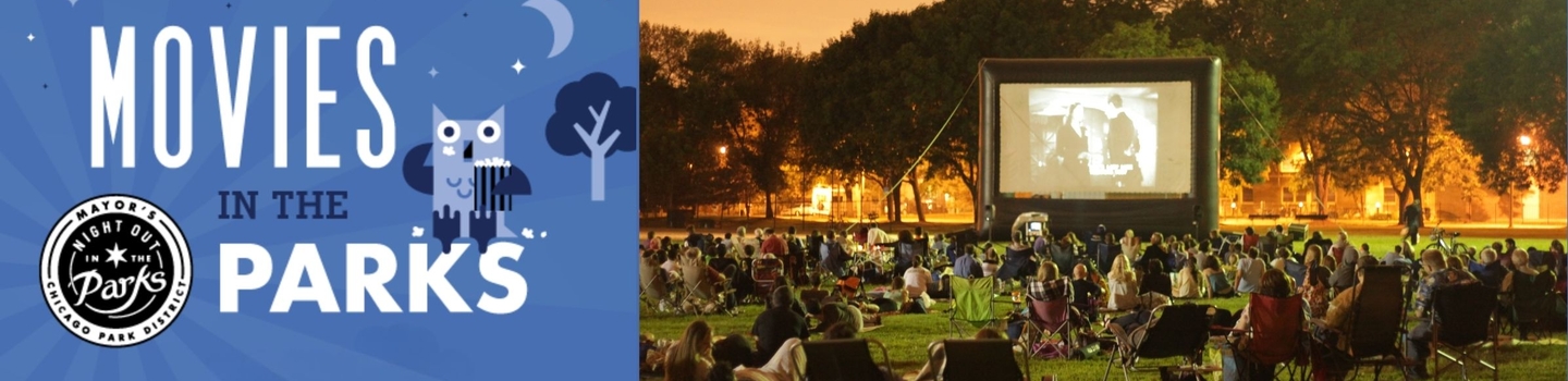 People watch a movie on an inflatable screen in a park at night.
