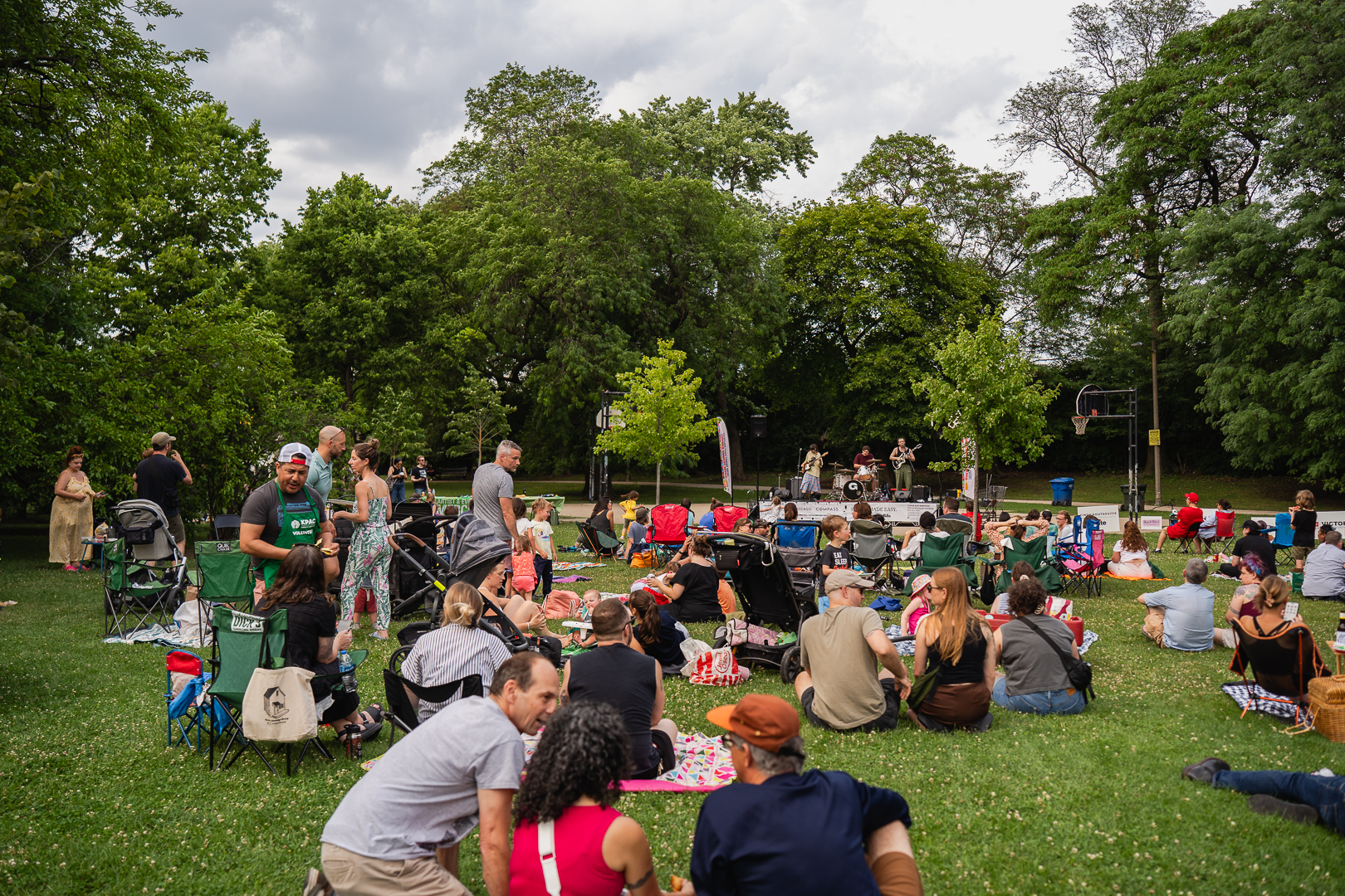Crowd enjoying an outdoor concert in a park.
