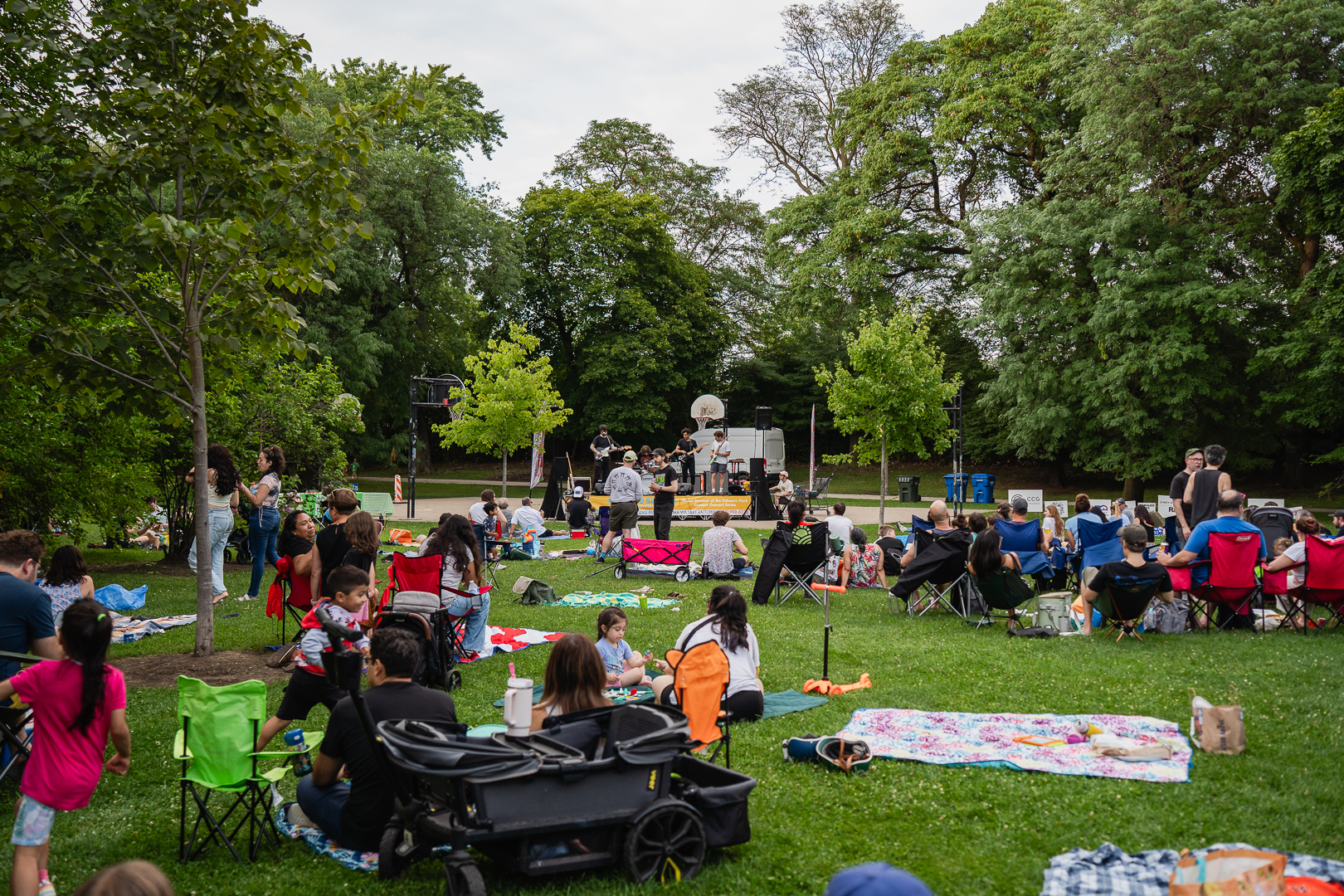 Crowd enjoying an outdoor concert in a park.
