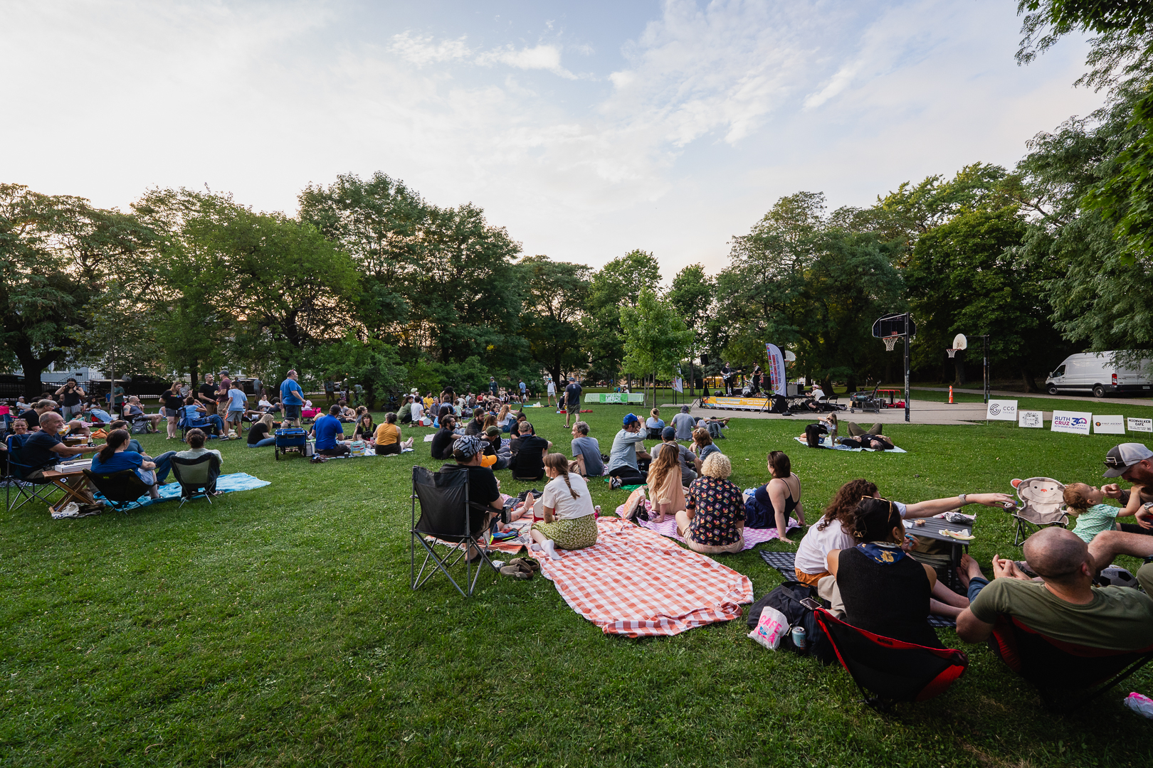 Crowd enjoying an outdoor concert in a park.