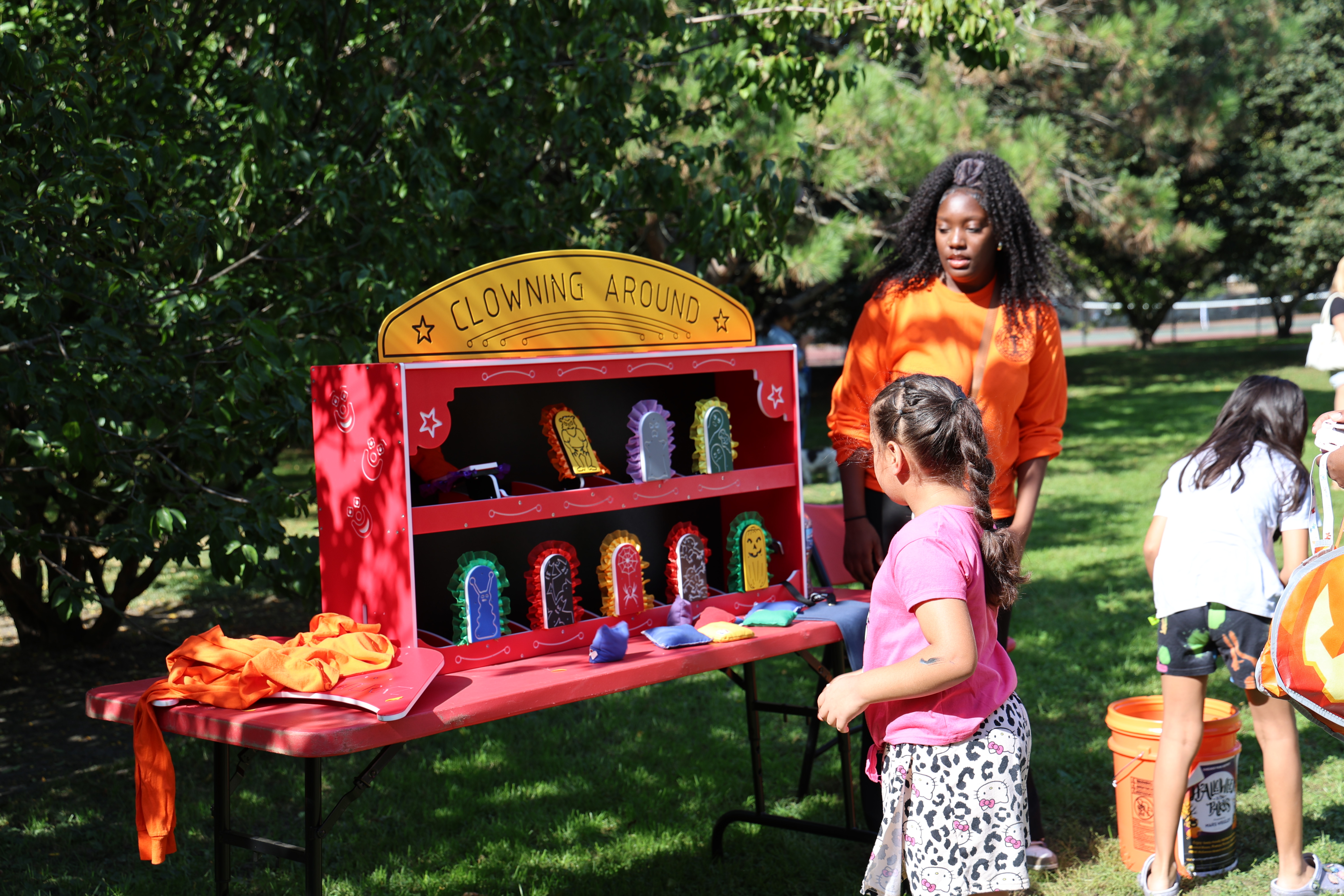Photograph of children playing a bean bag toss at a "Clowning Around" booth.