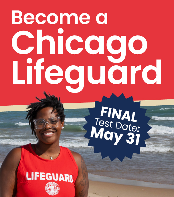 A smiling Chicago lifeguard stands on a beach.
