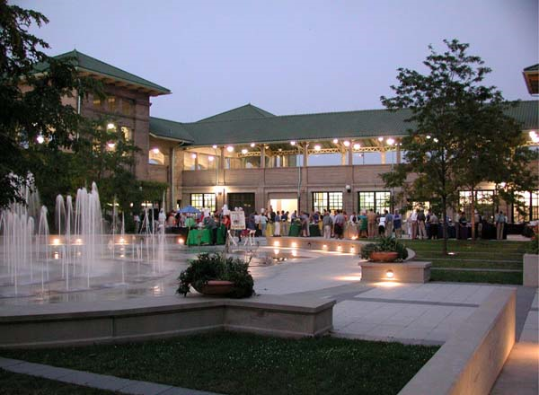 Evening gathering at a brick building with a courtyard fountain.