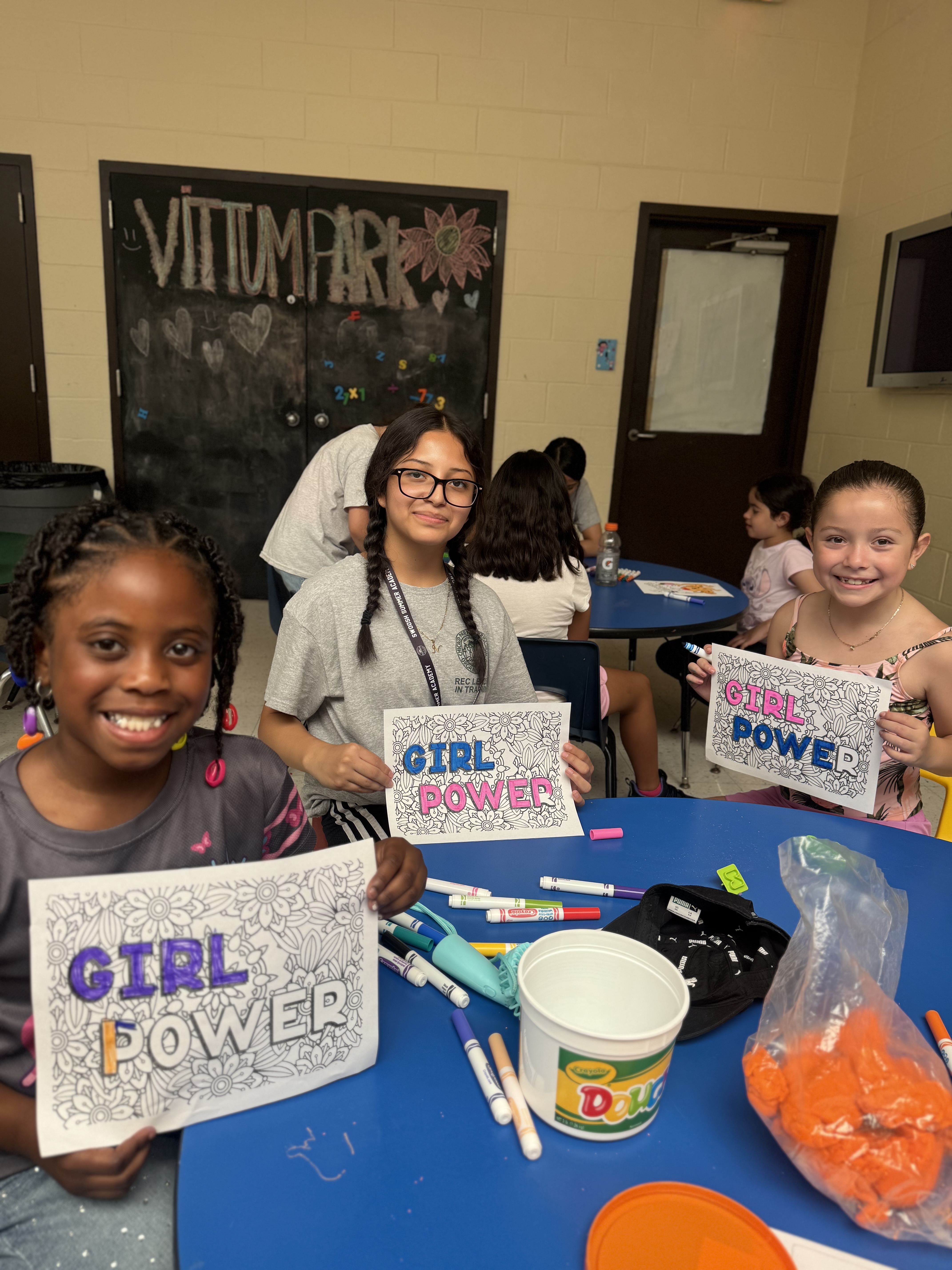 Three girls proudly display their "Girl Power" artwork.