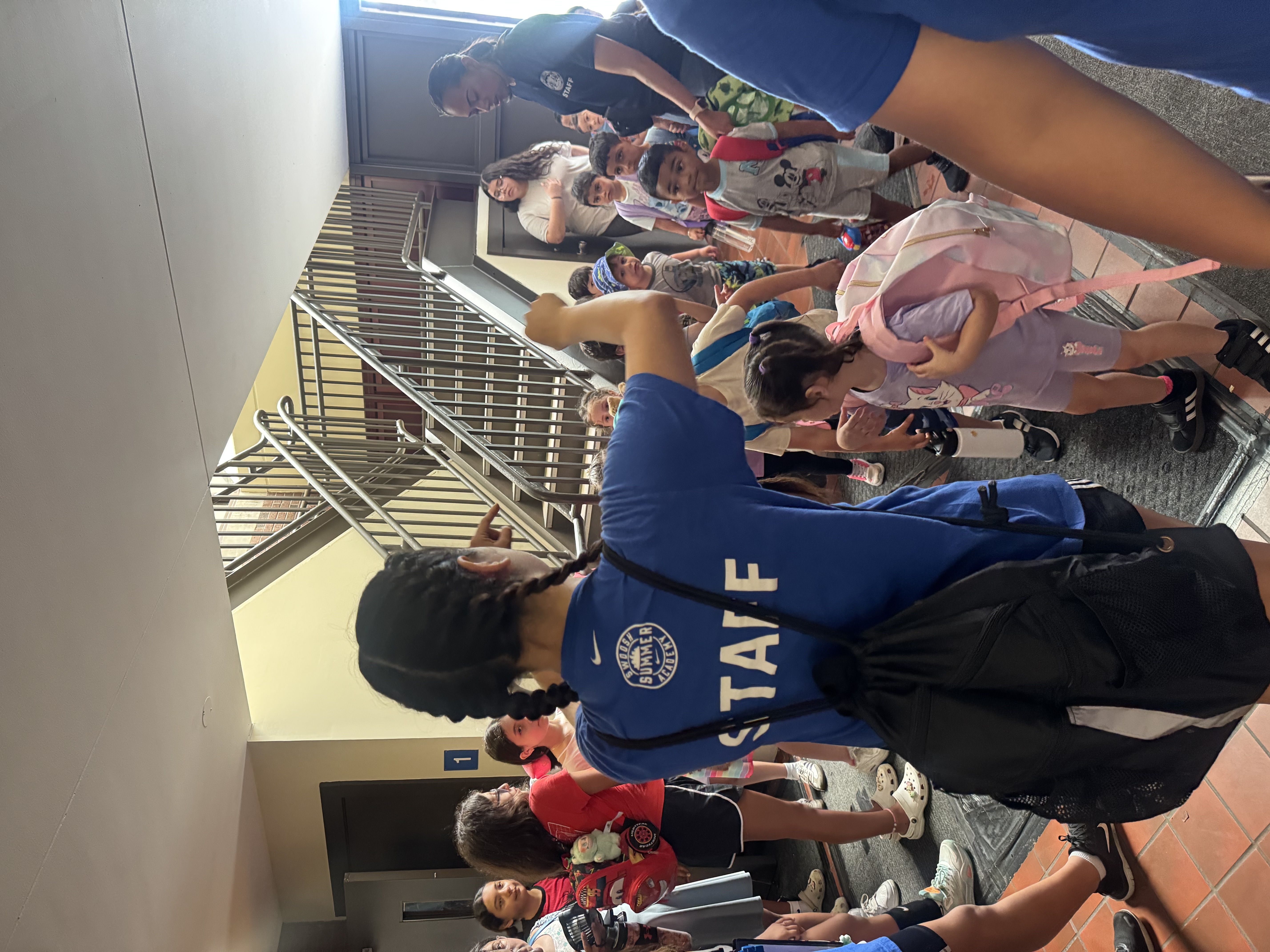 Children and staff walk down a stairwell.