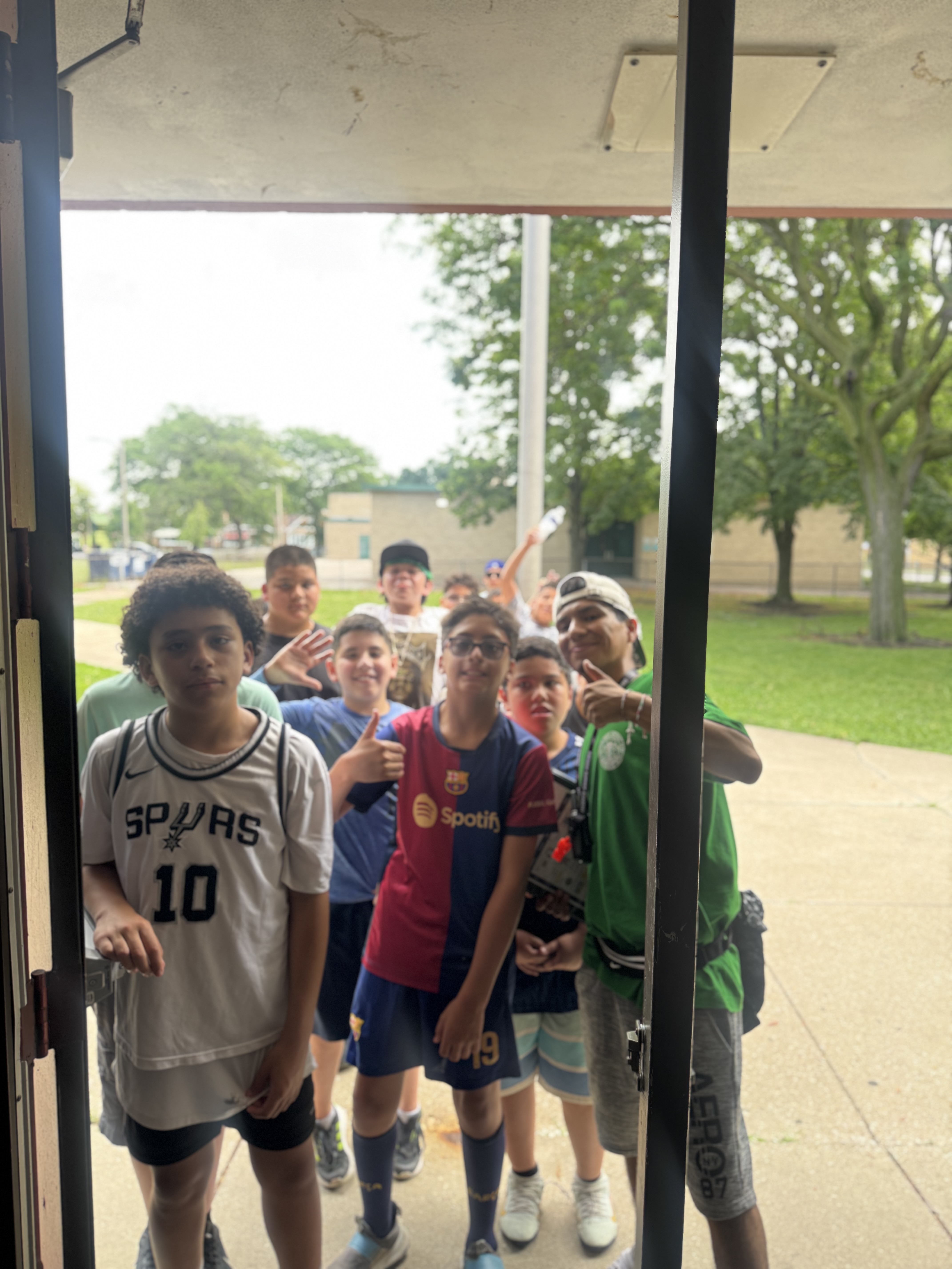 Group of boys in sports jerseys posing in a doorway.