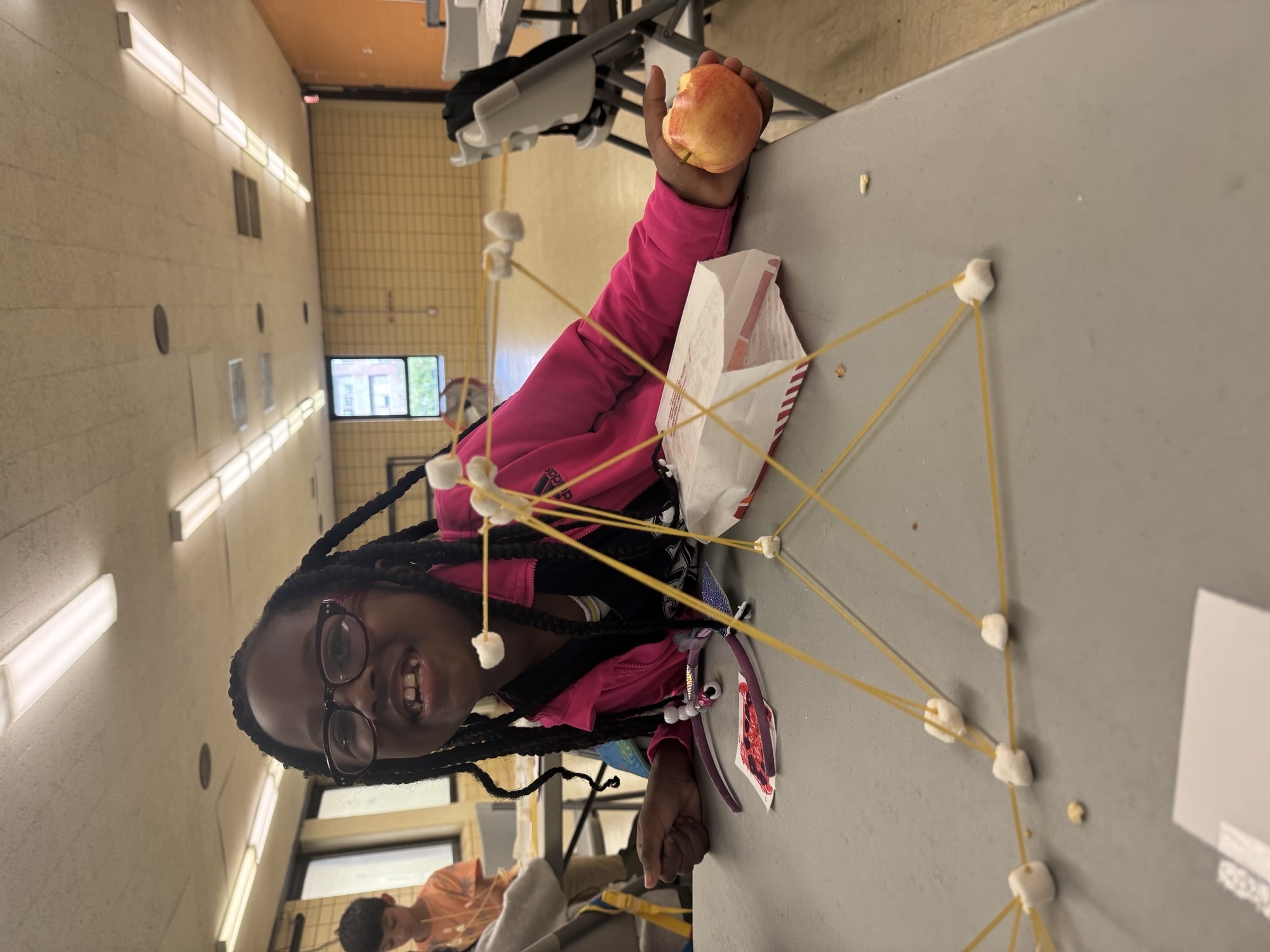 Photograph of student with marshmallow building.