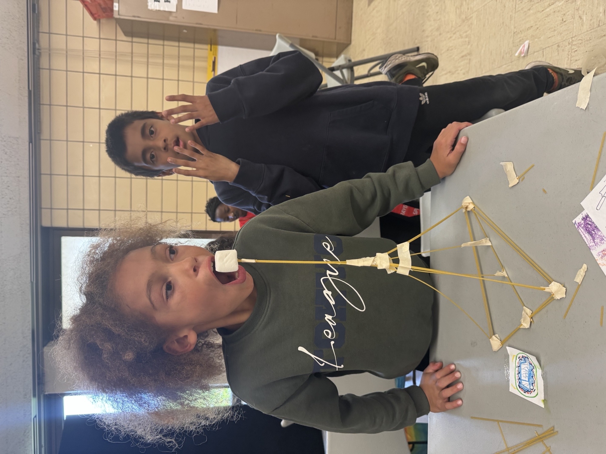 Kids building with spaghetti and marshmallows, photograph.